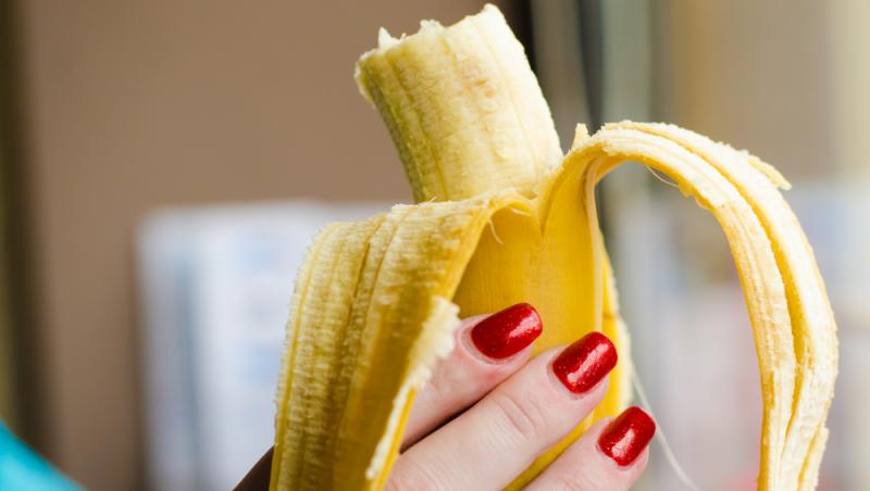 imagine cu o banana tinuta in mana unei femei