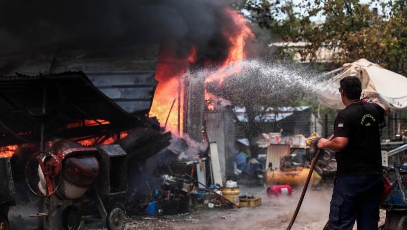 Pompier stingând flăcările din Grecia