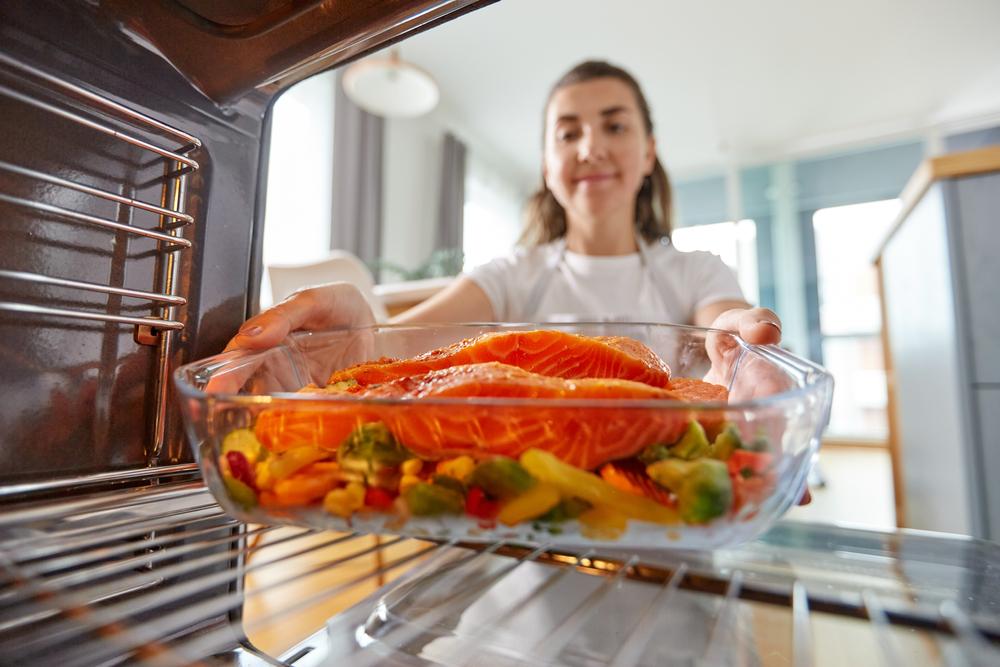 imagine cu o femeie gatind peste la cuptor