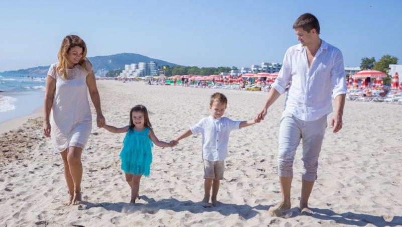 Familie care se tine de mana pe plaja din Albena