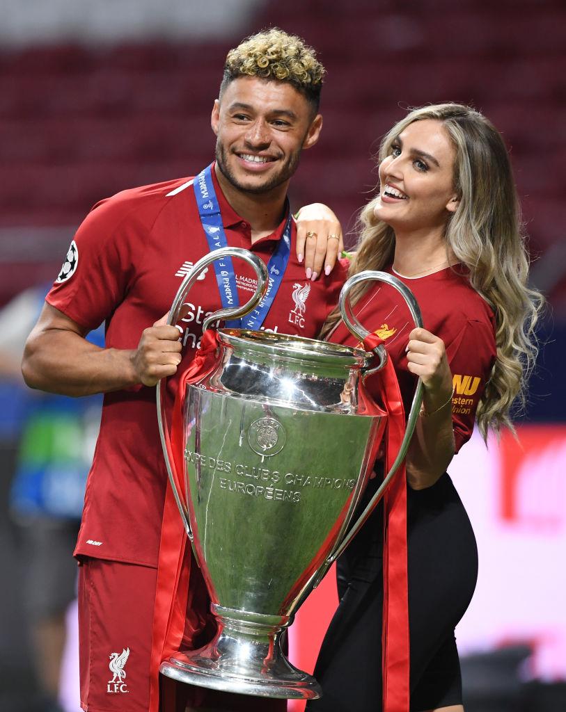 Perrie Edwards și fotbalistul Alex Oxlade, imbracati in echipament sport. El are o cupa in mana