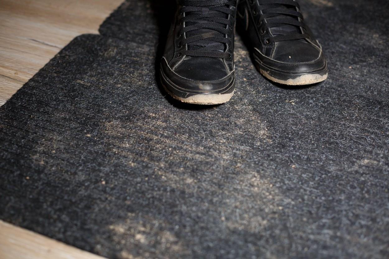 imagine cu pantofii unui barbat care sta pe o podea veche