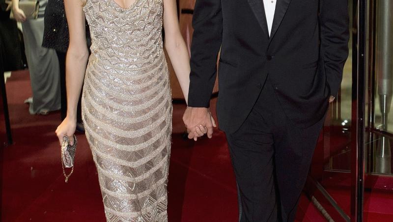 beatrice borromeo și soțul ei, pierre casiraghi, la Rose Ball 2015, pe covorul roșu, mergând. el poartă un costum negru, cu papion  negru și cămașă albă, ea poartă o rochie argintie, accesorizată cu o geantă plic