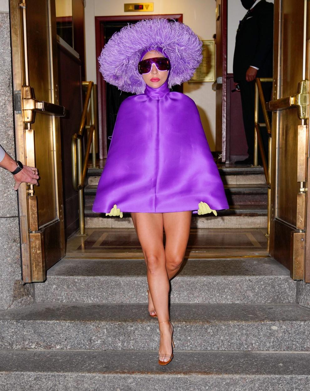 lady gaga intr-o rochie mov scurta cu o palarie mov pe cap si o pereche de ochelari de soare, coborand scarile