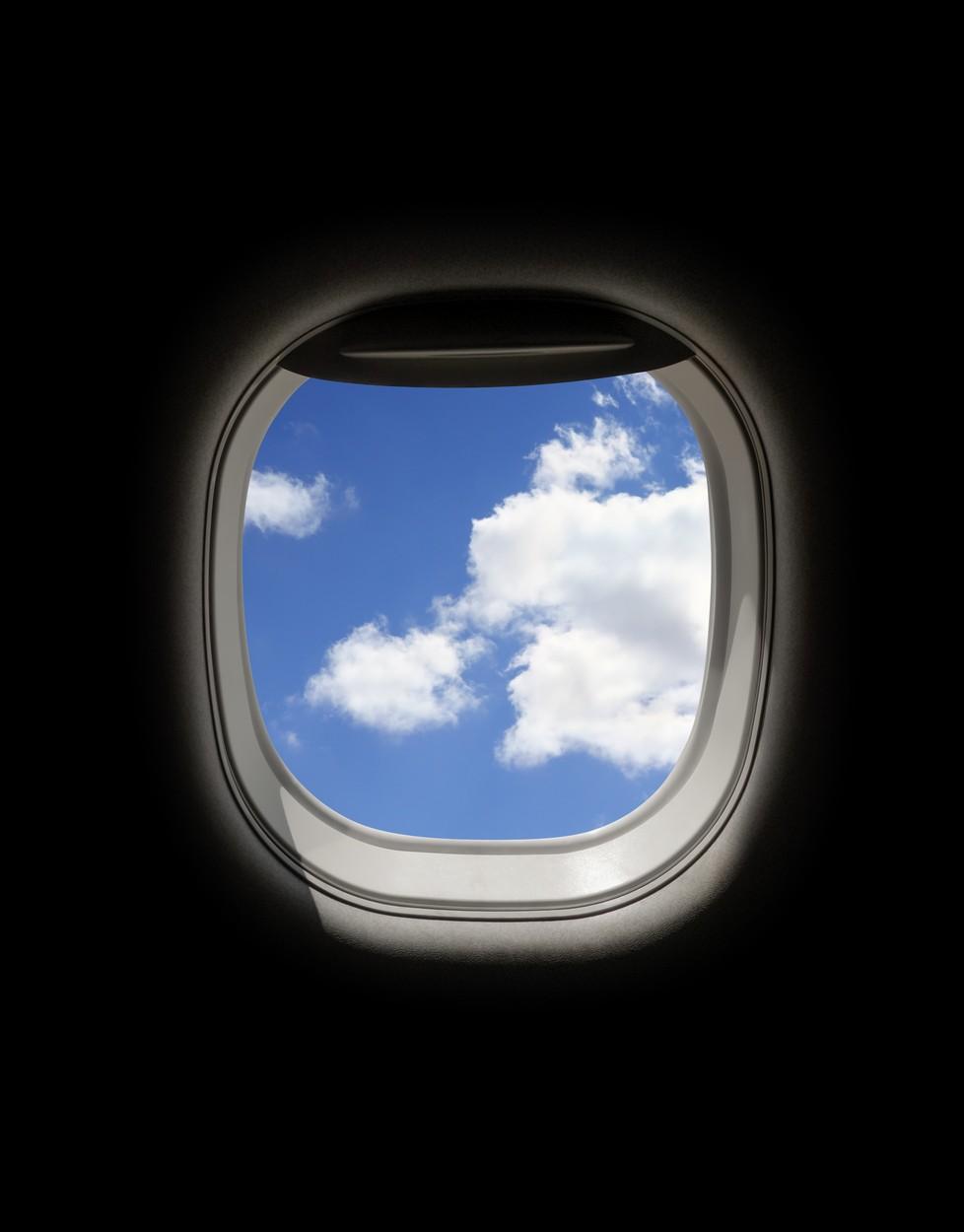 fereastra rotunda din avion prin care se vede cerul