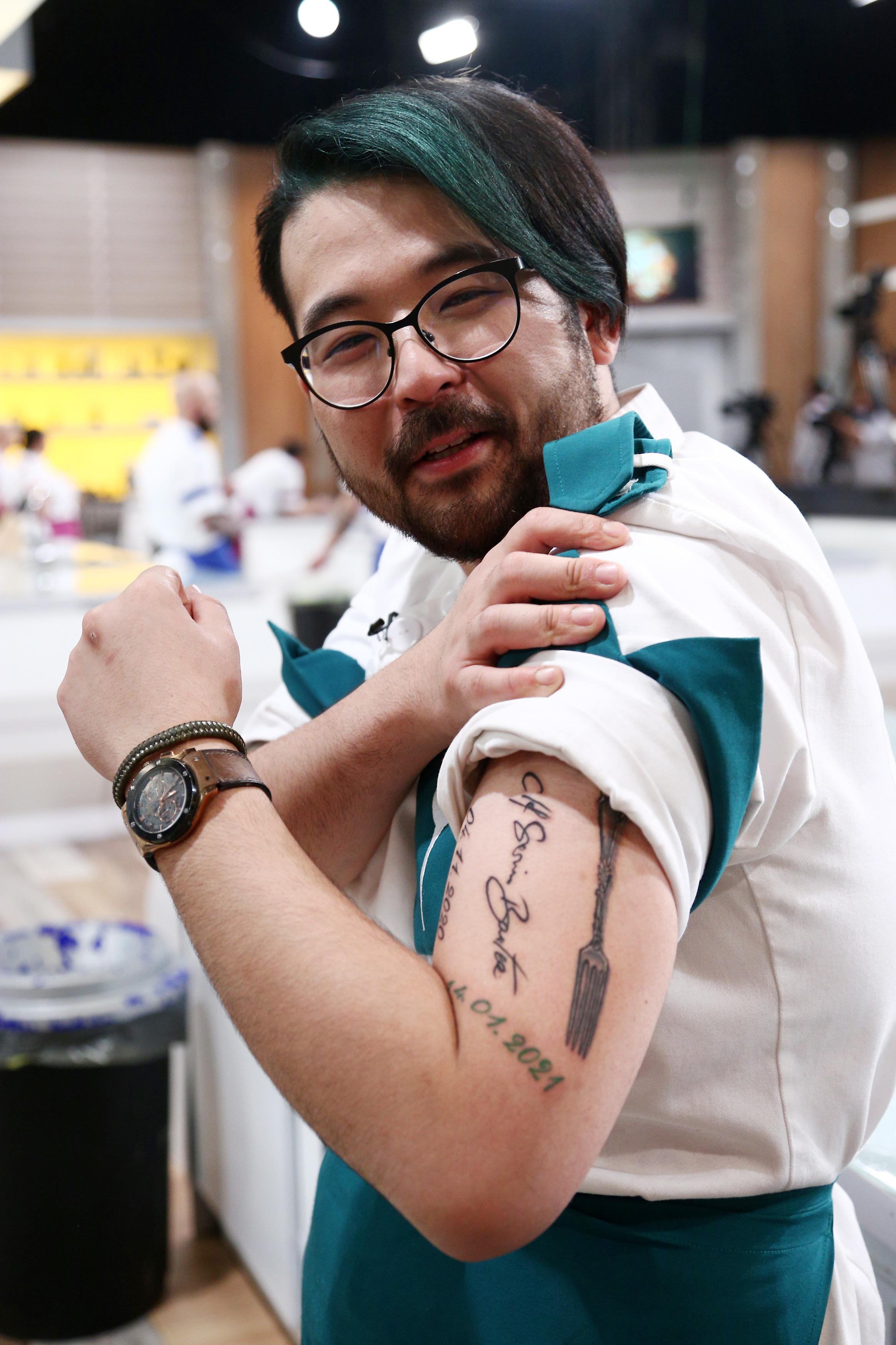 Riki de la Chefi la cuțite, arâtându-și tatuajul pe car eși l-a făcut cu semnătura lui Sorin Bontea