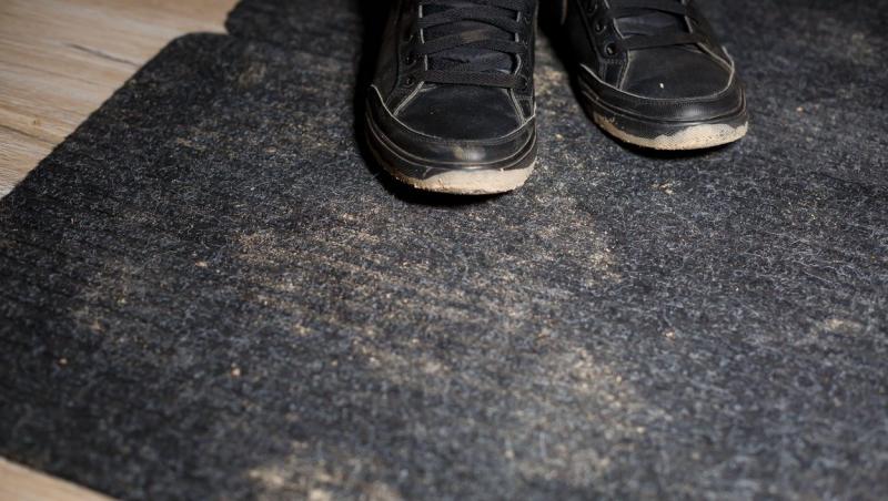 imagine cu pantofii unui barbat care sta pe o podea veche