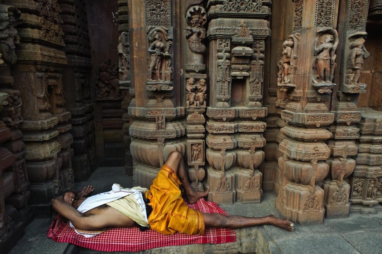 imagine cu un bărbat indian dormind într-un templu, pe jos