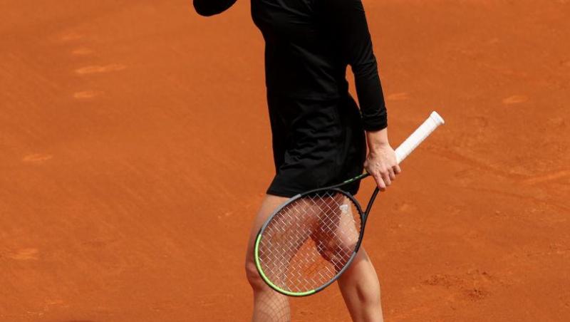 Simona Halep pe terenul de teren cu paleta de tenis în mână