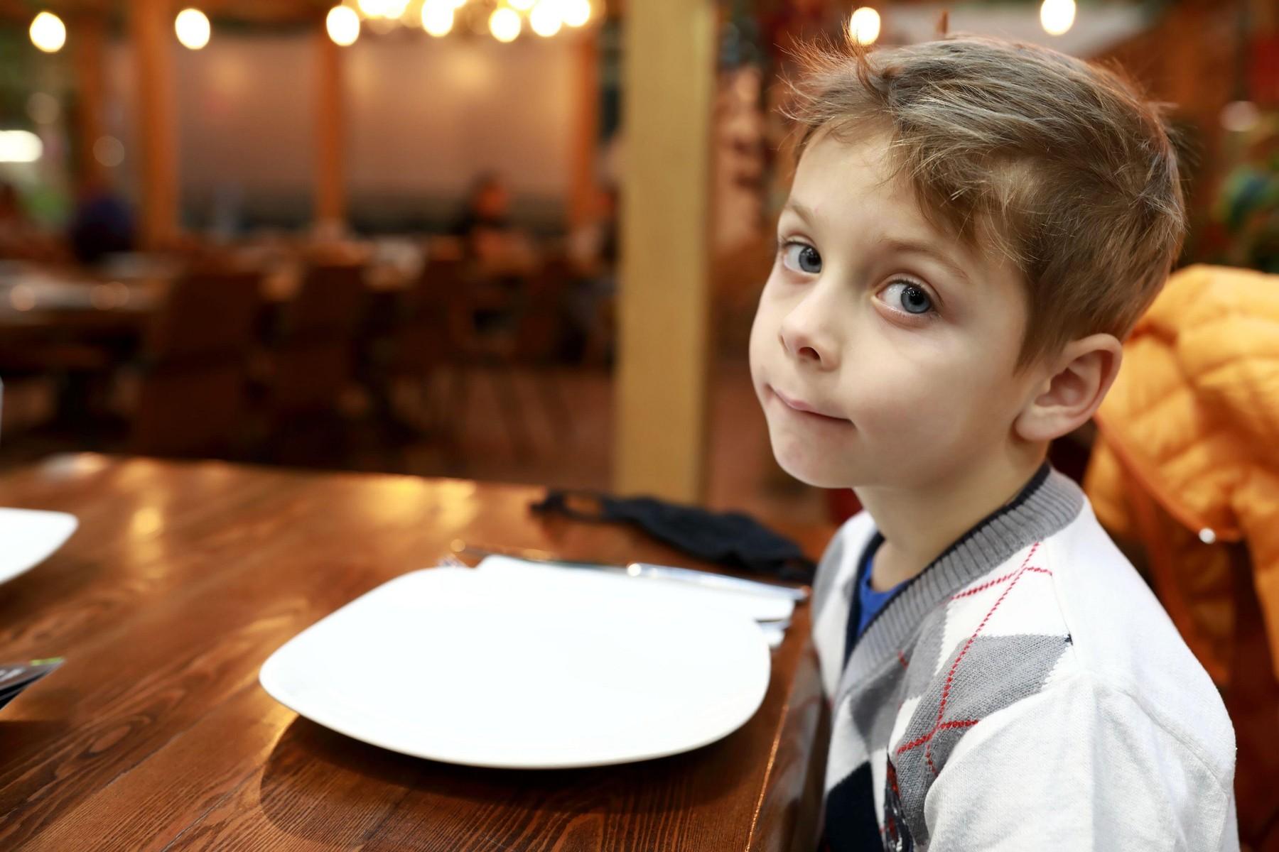 un băiețel luand masa