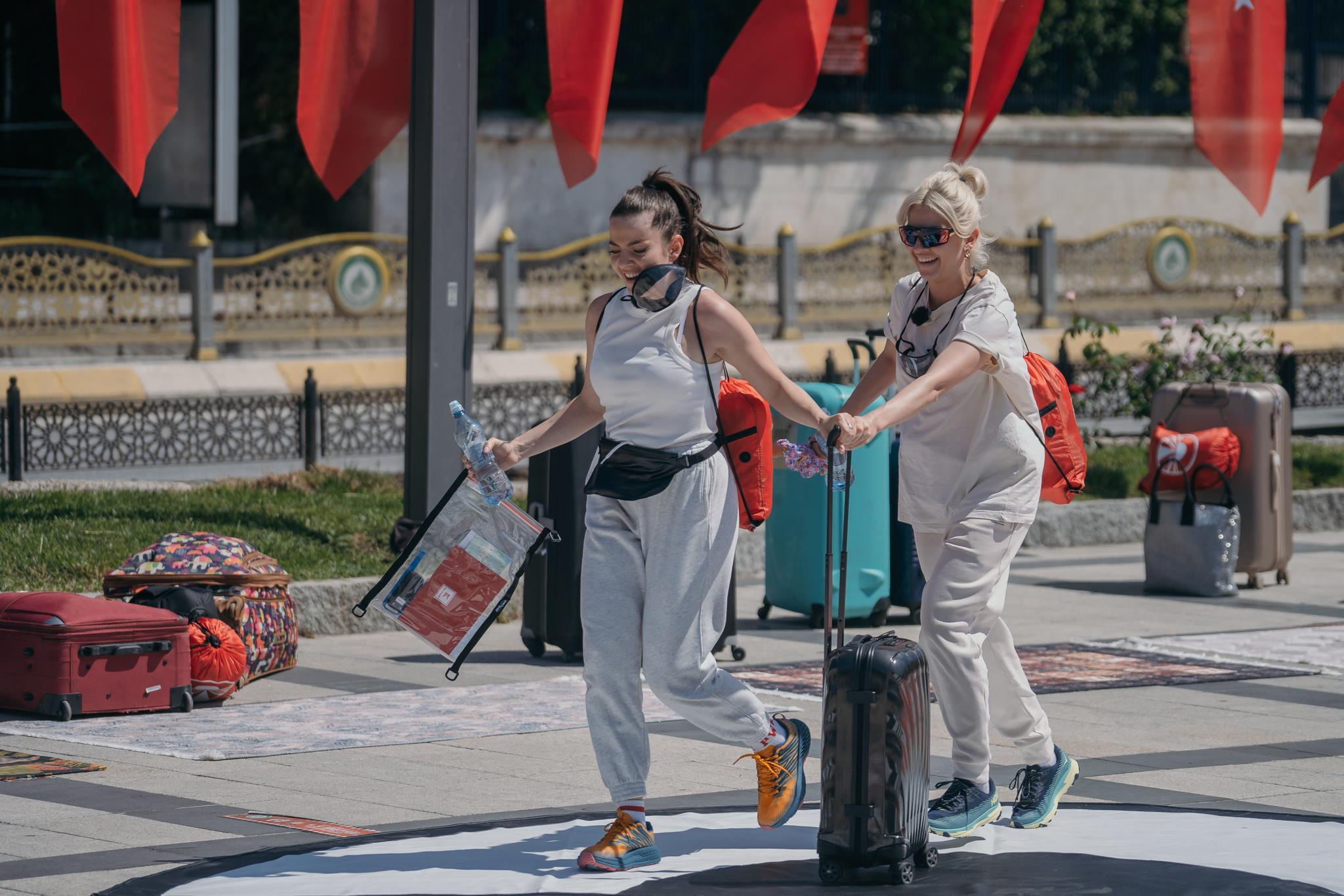 Lidia Buble și Estera cu bagale în mână, aleargă