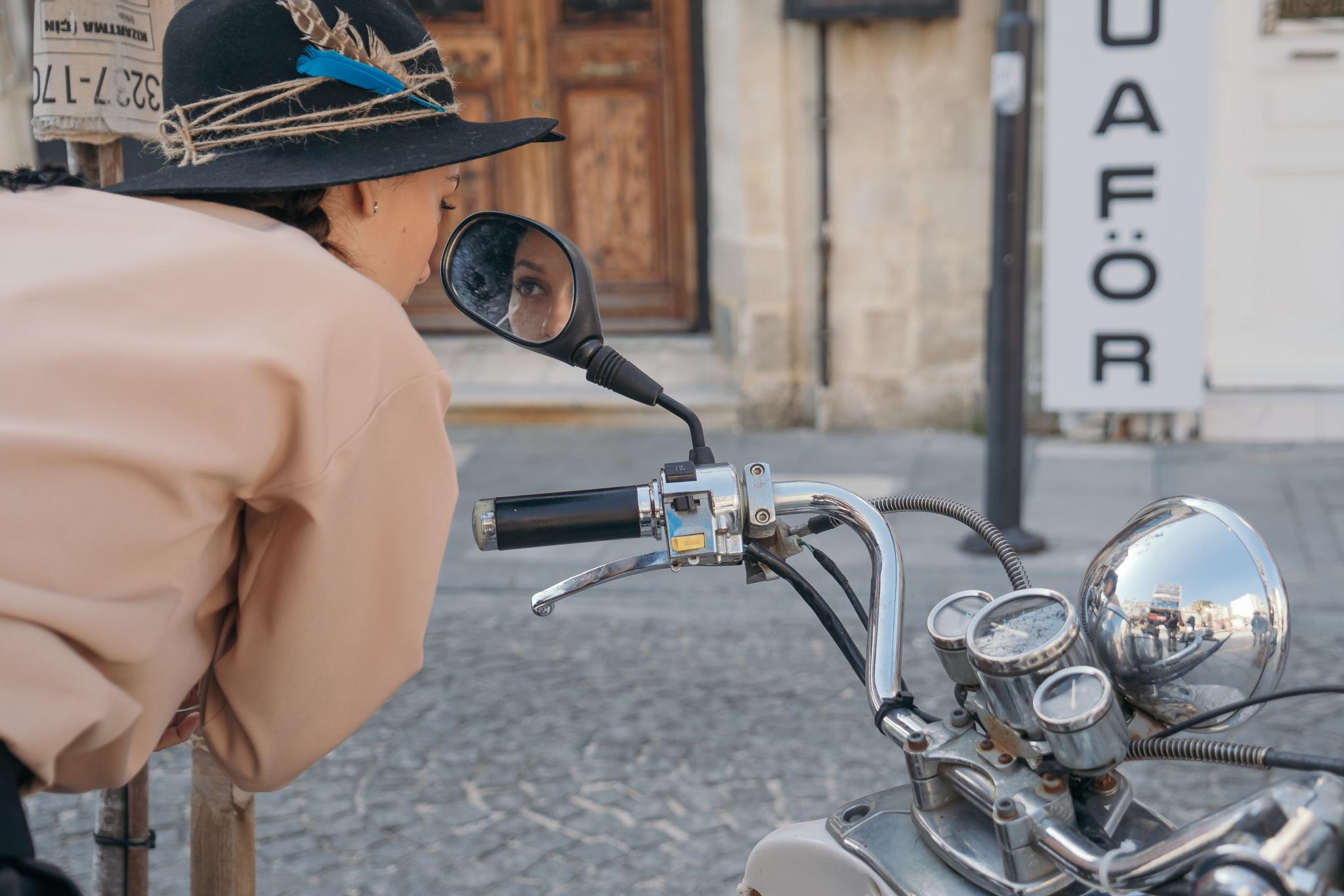 Irina Fodor se uită în oglina unei motociclete