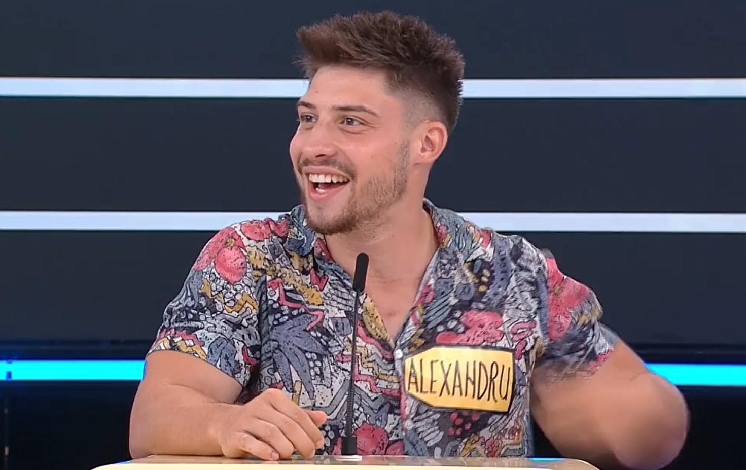 Alex Oianu în cămașă înflorată, zâmbește