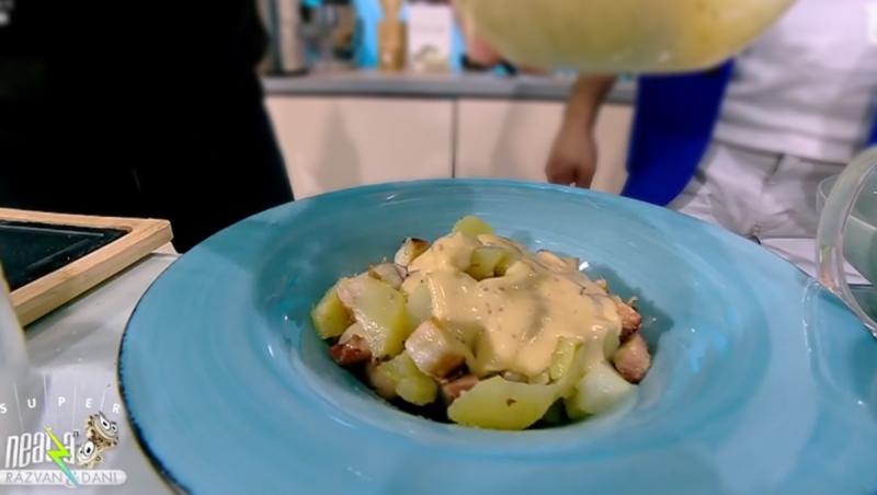 Salată de cartofi cu caracatiță și sos de brânzeturi într-o farfurie bleu