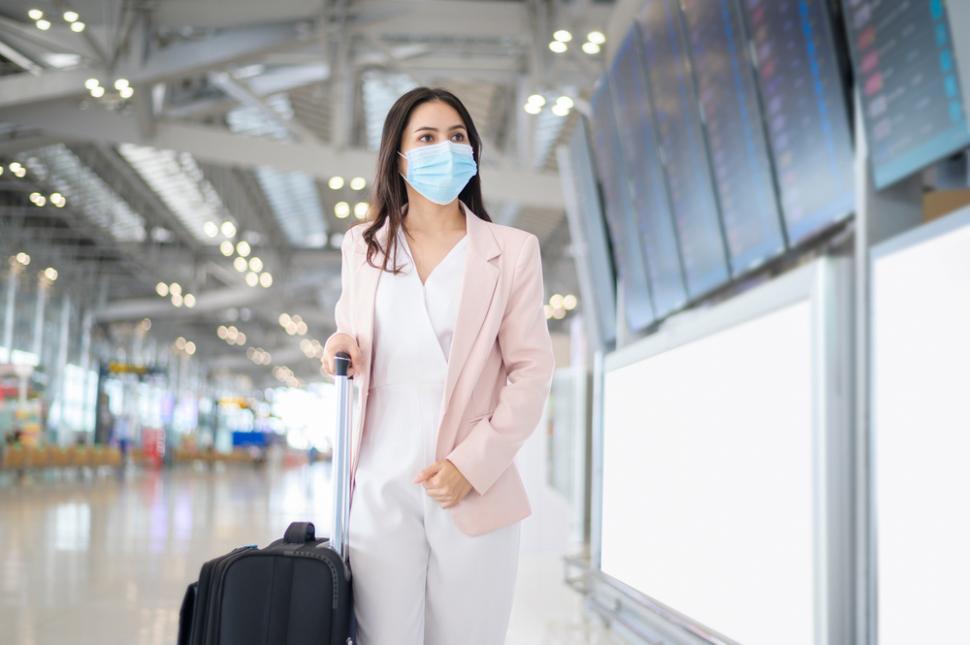 Femeie în aeroport, cu mască