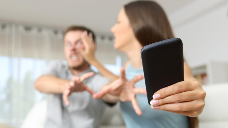 barbat si femeie certandu-se pe telefonul mobil
