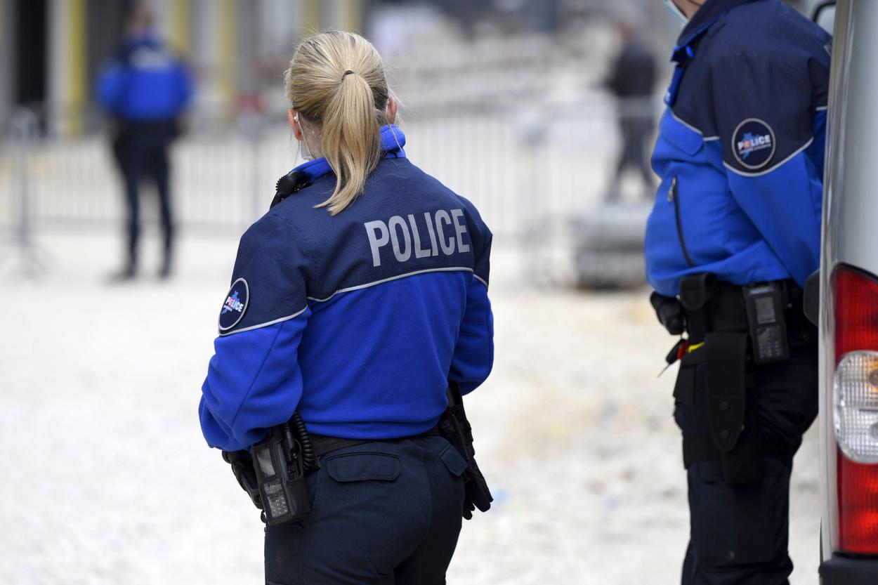 femeie blonda imbracata in uniforma de politista sta cu spatele