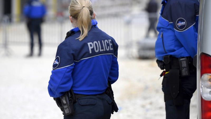 femeie blonda imbracata in uniforma de politista sta cu spatele
