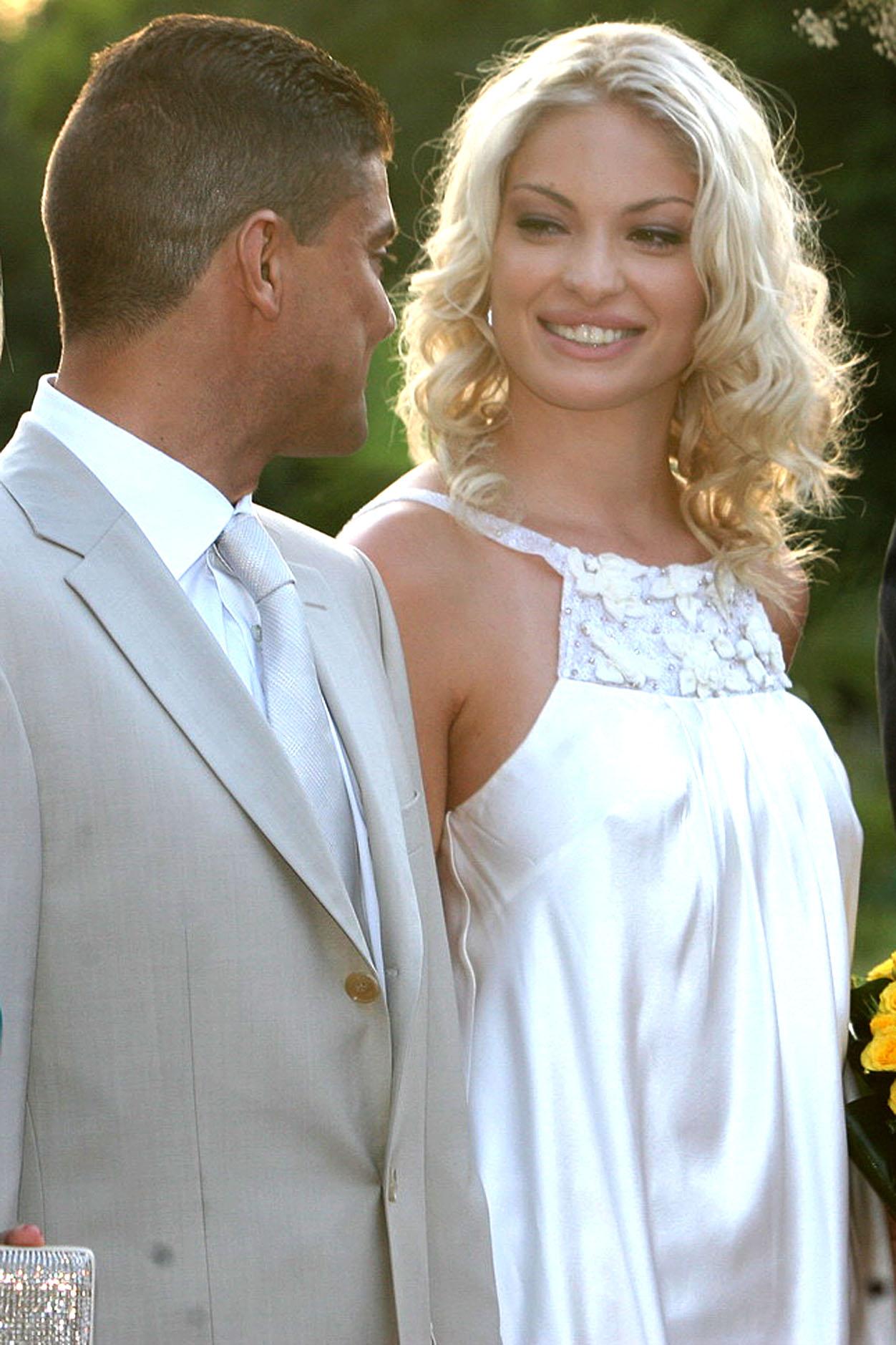 Valentina Pelinel într-o rochie albă din satin, zâmbește către un bărbat