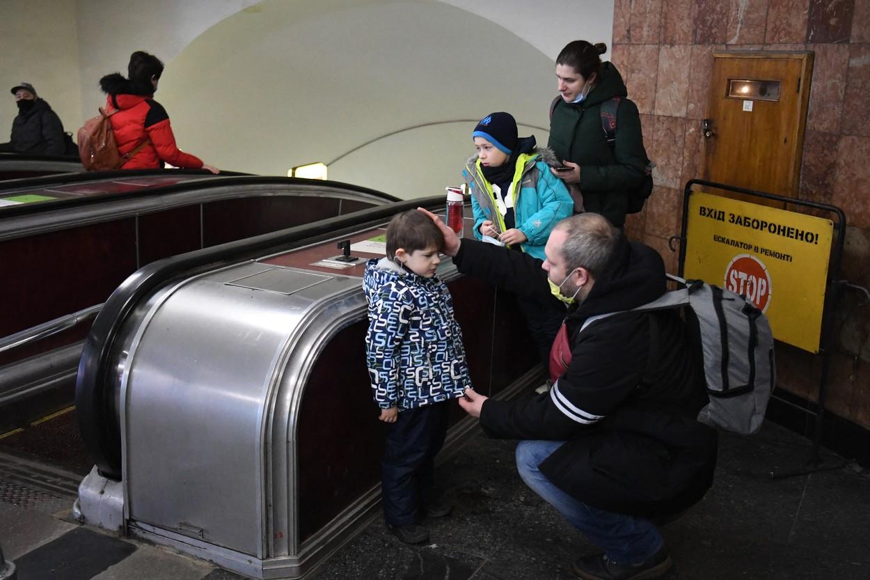familie cu doi copii pe care tatal ii consoleaza la metrou in kiev