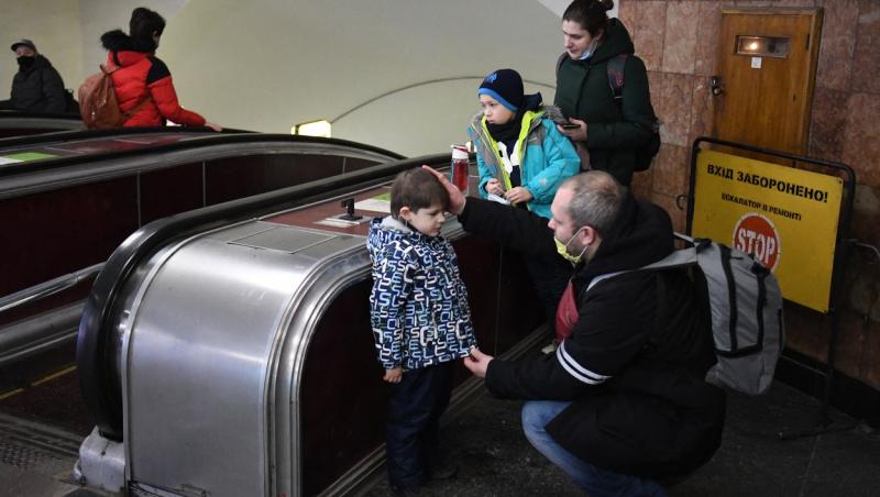 familie cu doi copii pe care tatal ii consoleaza la metrou in kiev