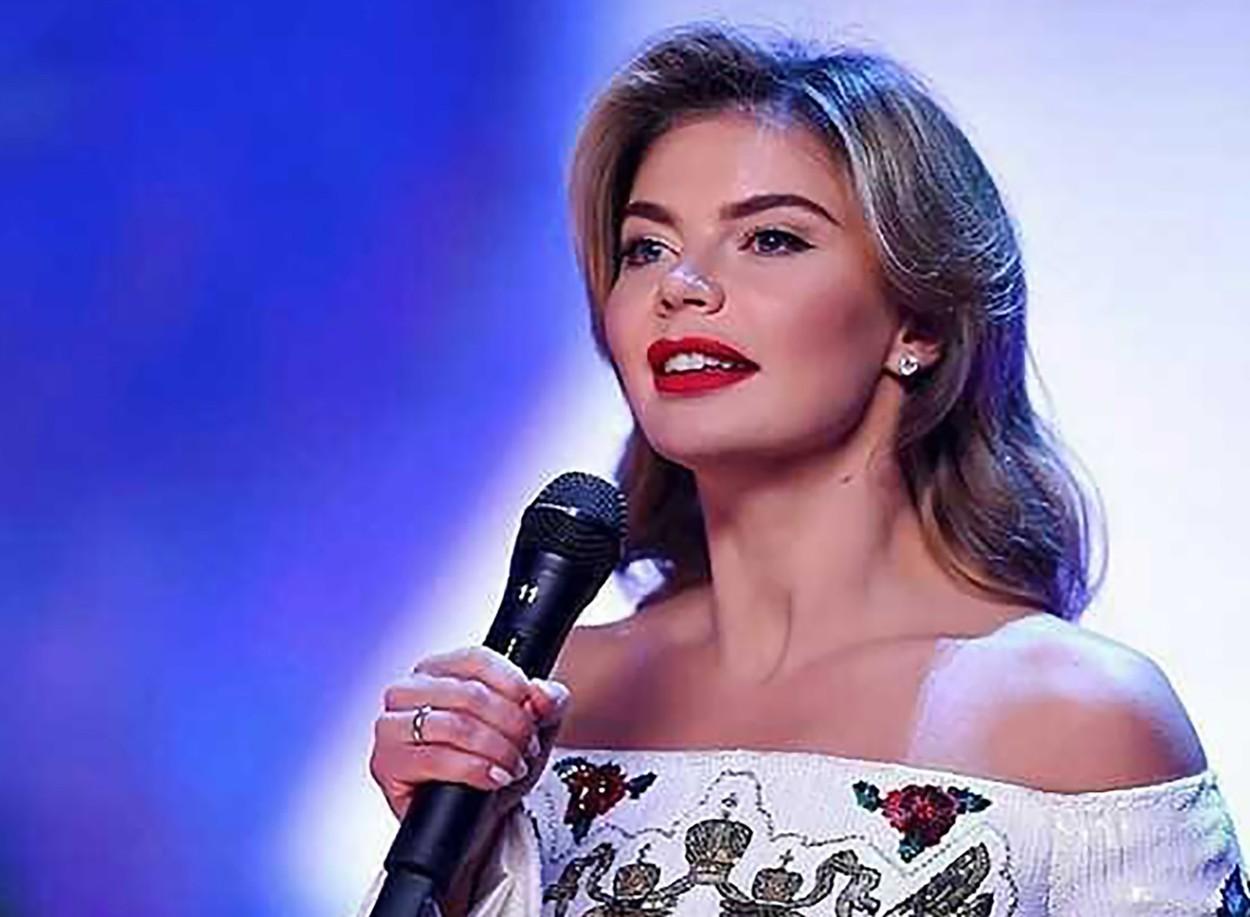 alina kabaeva imbracata intr-o rochie alba cu imprimeu floral