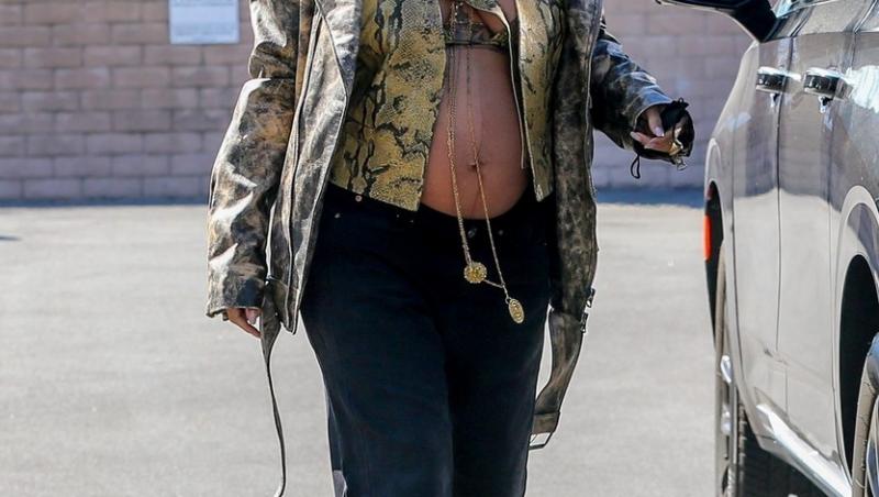 Rihanna într-o vestă scurtă și o jachetă largă, merge pe stradă