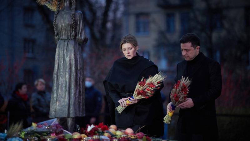 olena zelenska si volodimir zelenski imbracati in negru in timp ce pun flori langa o statuie