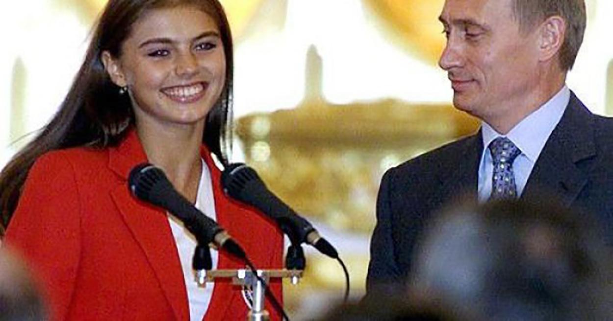 vladimir putin o priveste pe alina kabaeva in timp ce gimnasta zambeste