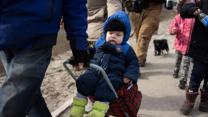 bebelus pus pe un troler tras de parinte pe colidorul umanitar din ucraina