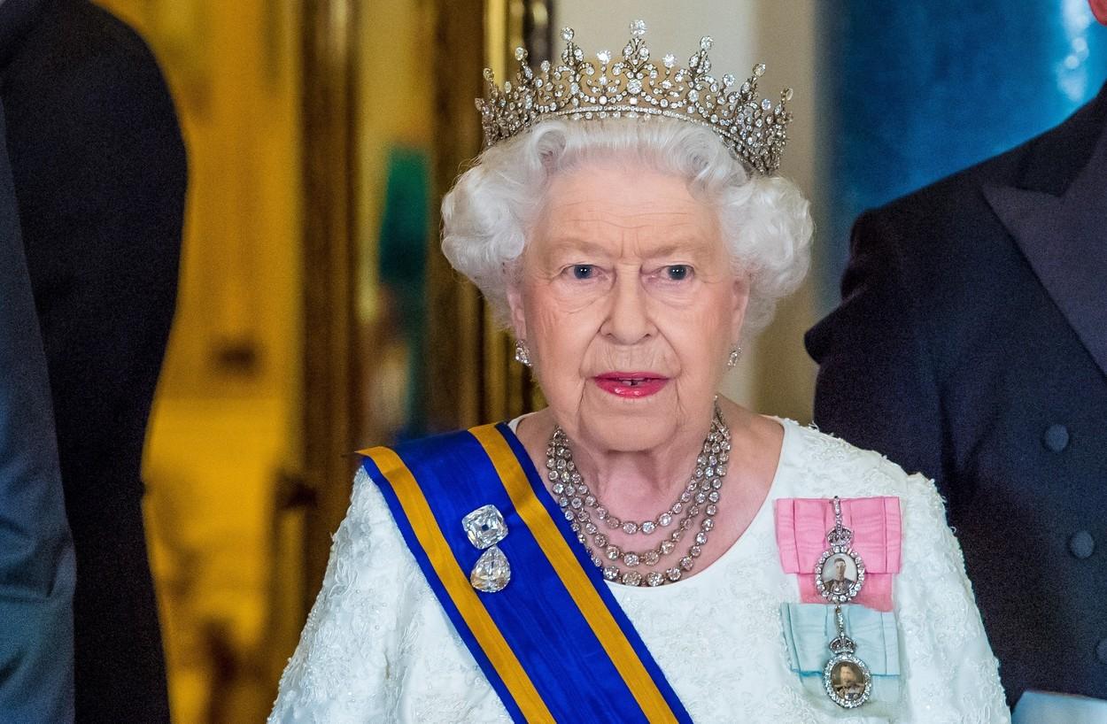 regina elisabeta a II-a in rochie alba cu corona pe cap