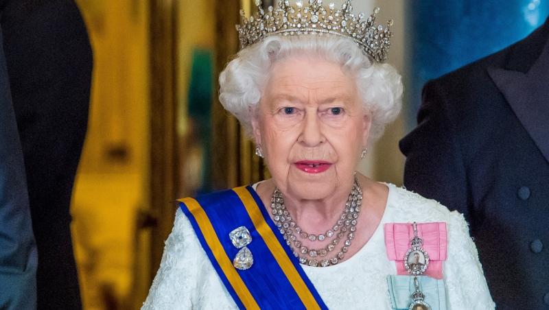 regina elisabeta a II-a in rochie alba cu corona pe cap