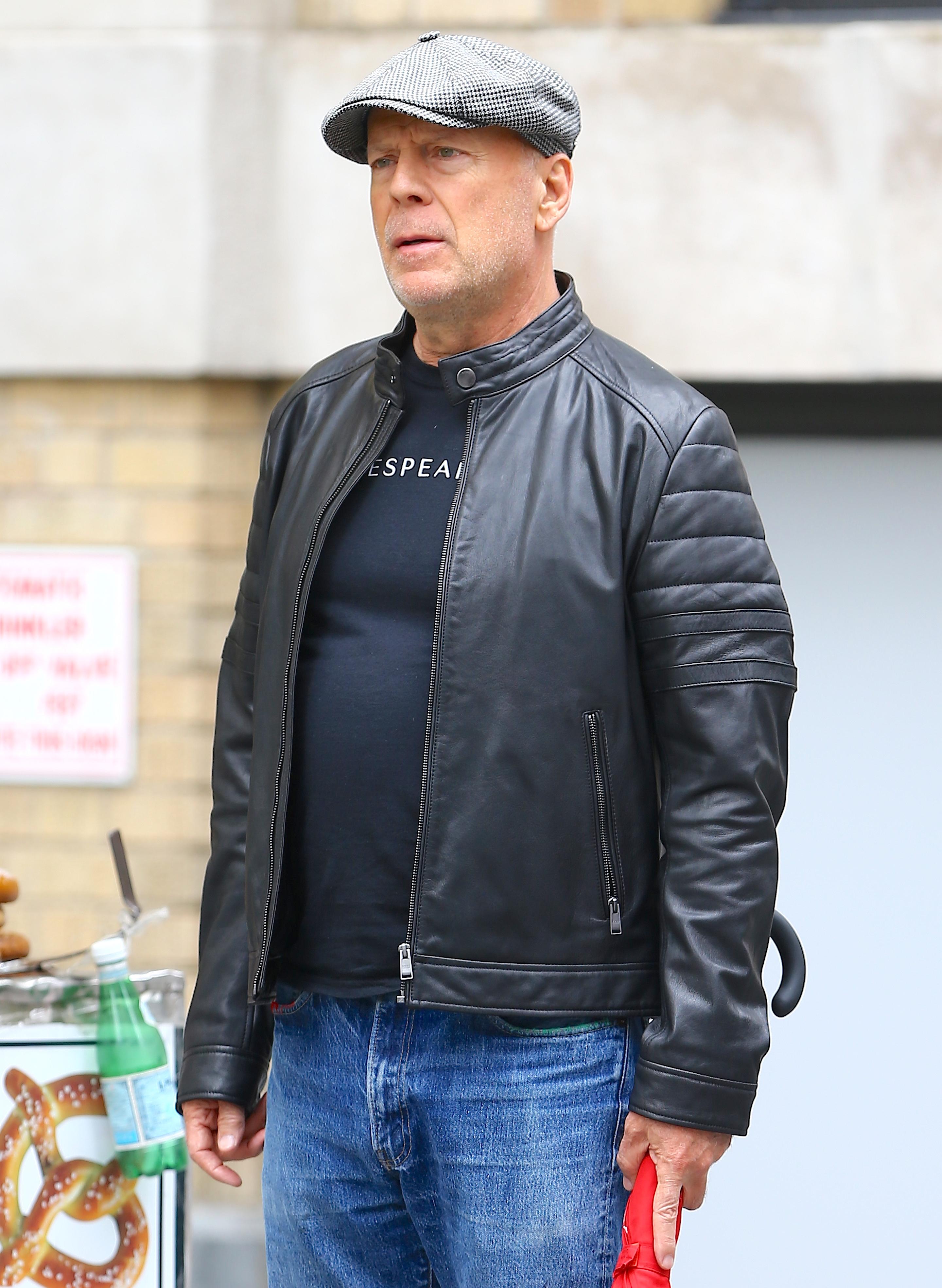 Bruce Willis în geacă de piele la aeroport