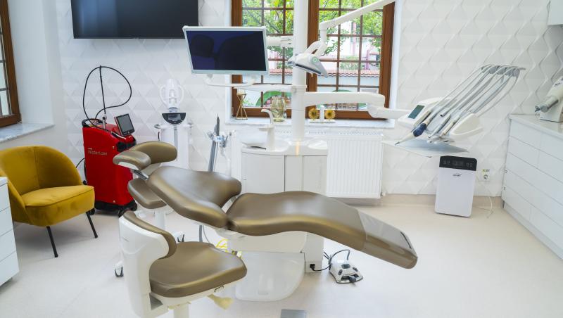 interiorul unui cabinet dentar cu scaun pt pacient si mobilier