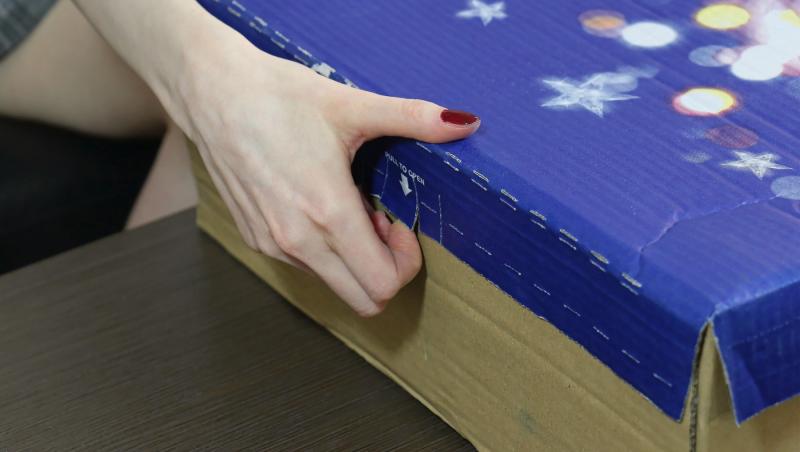 imagine cu o mana de femeie pe o cutie de produs comandat
