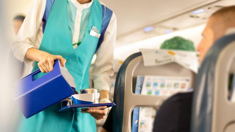 imagine cu o stewardesa servind ceai si cafea in avion