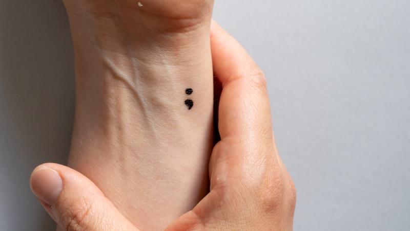 Ce înseamnă dacă cineva are un tatuaj cu un punct și o virgulă, de fapt. Semnificația ascunsă a acestui desen