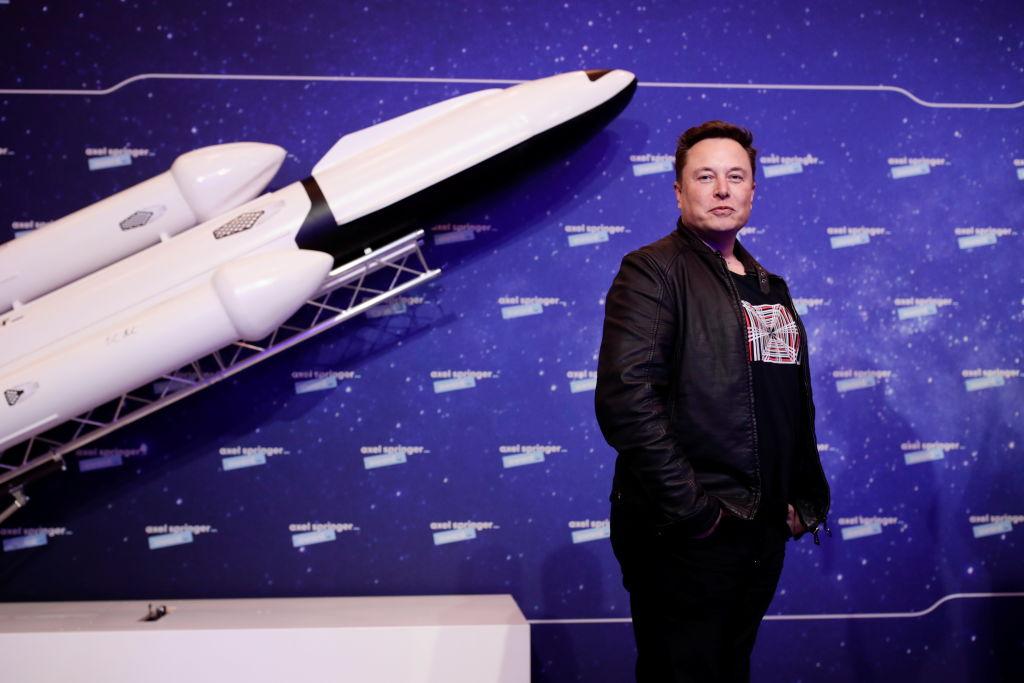 elon musk imbracat in negru in fata unei rachete