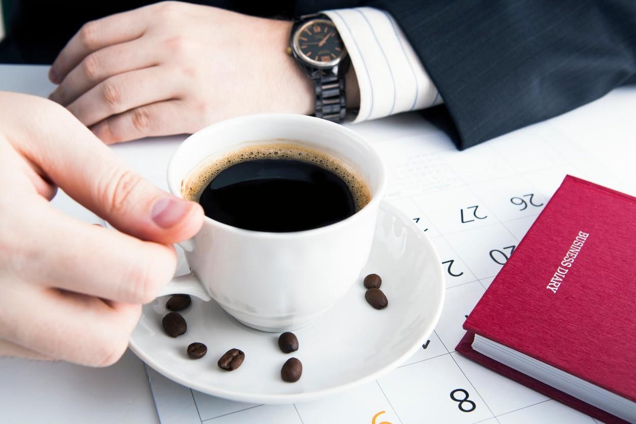 imagine cu o persoana care bea cafea dintr-o ceasca alba la interviul de angajare