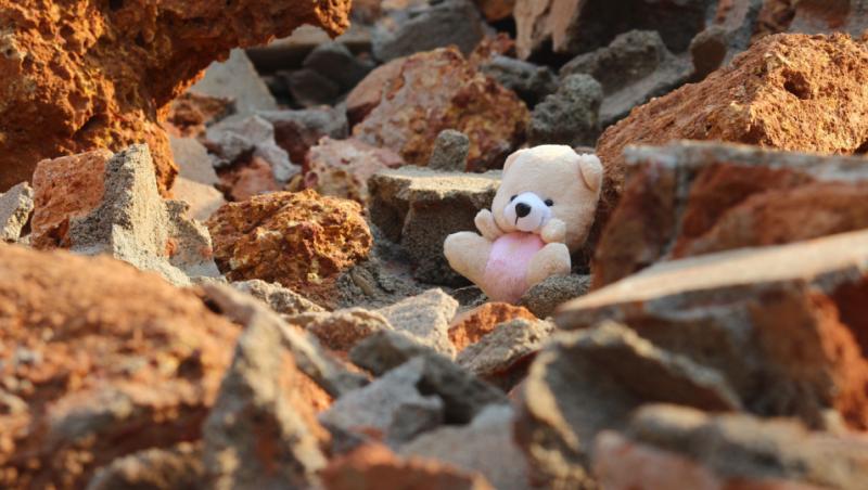 O jucărie de pluș în formă de ursuleț uitată pe un pământ lovit de cutremur