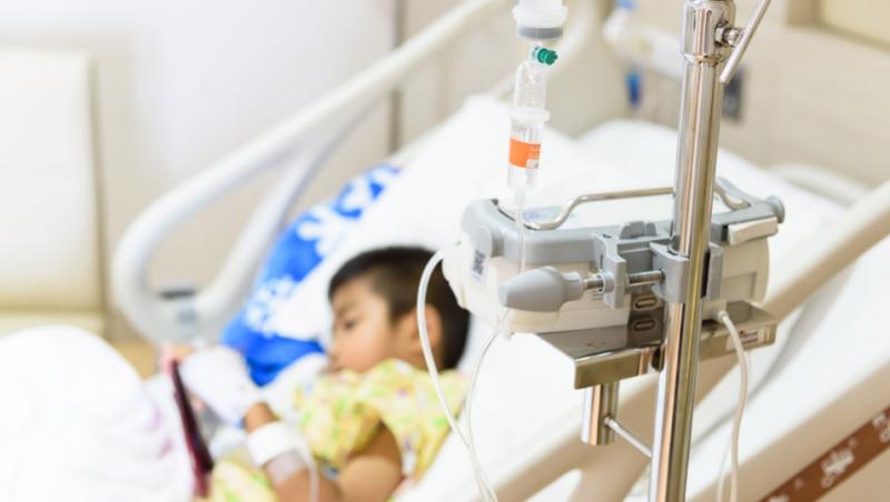 Copil bolnav internat în spital care stă în pat