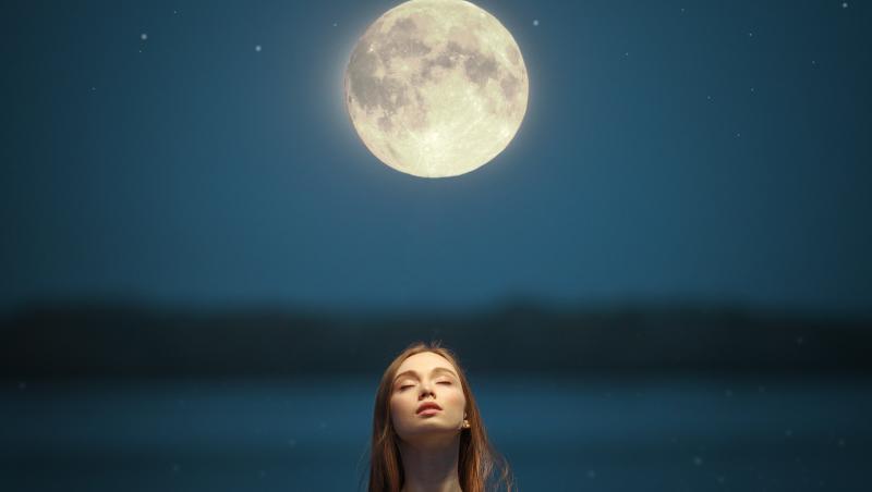 Imagine cu o doamnă care privește în sus spre Lună