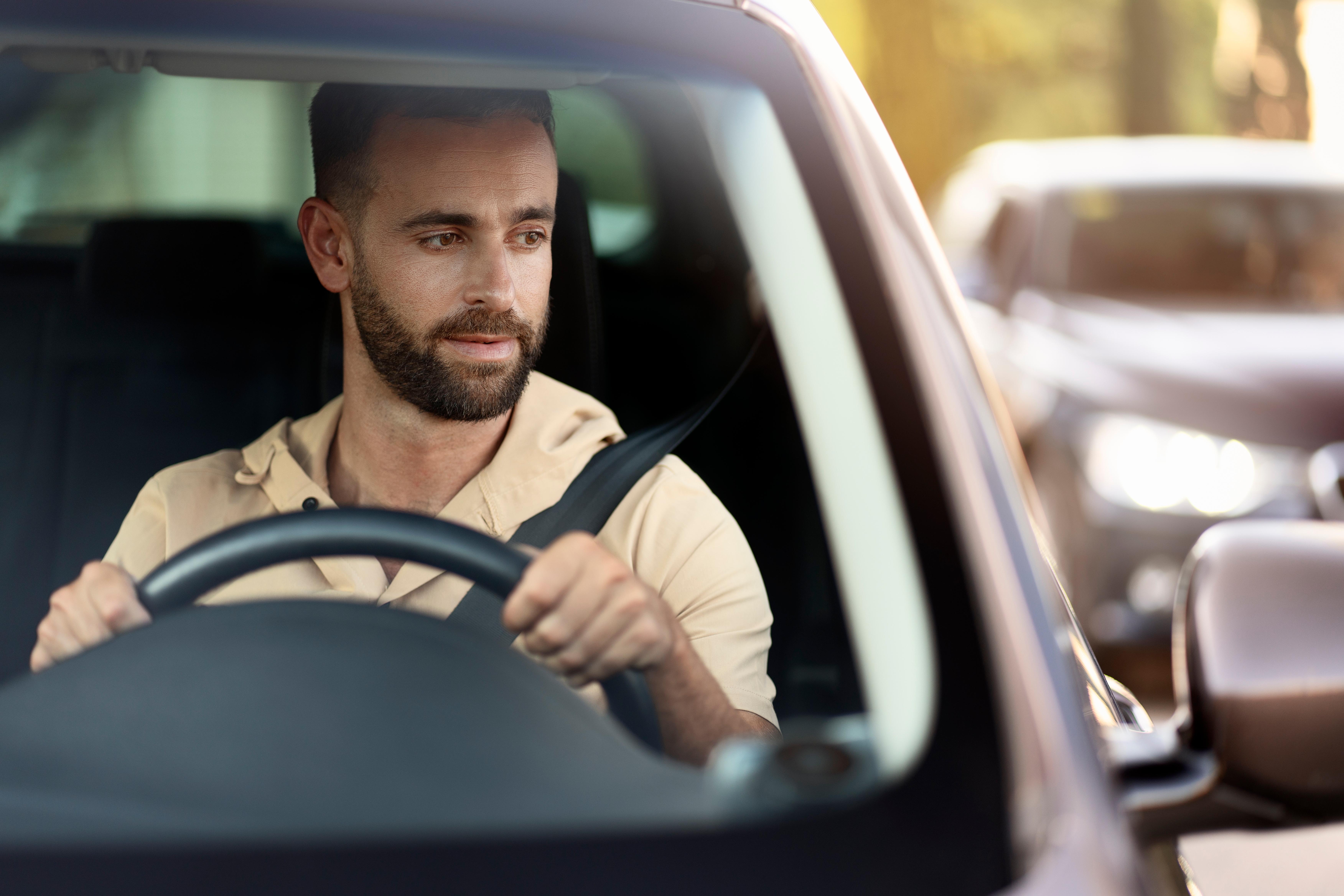 Imagine cu un șofer care se asigură în oglindă pentru a putea efectua o manevră în siguranță.