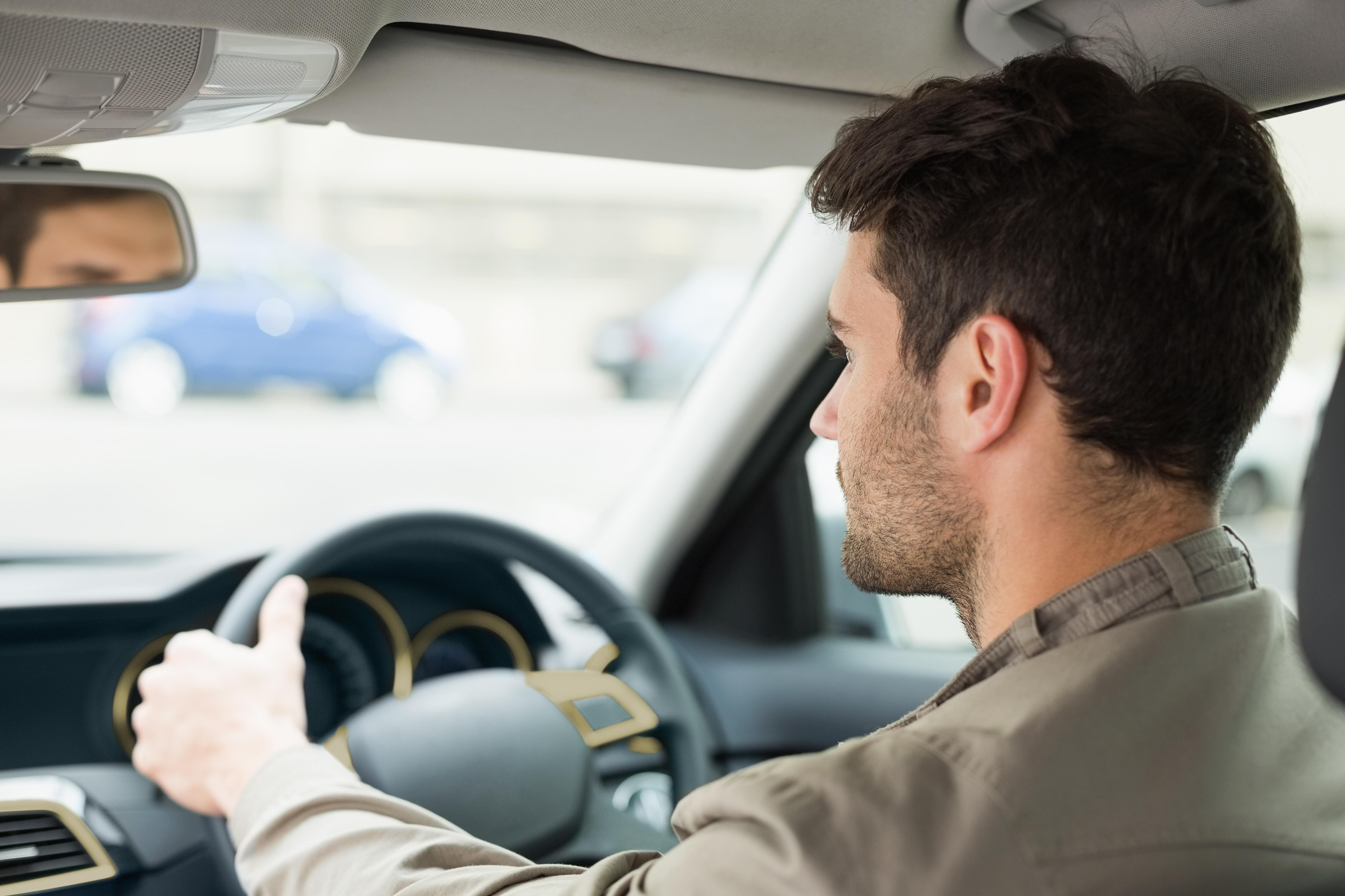 Imagine cu un șofer care este atent la trafic în timp ce conduce.