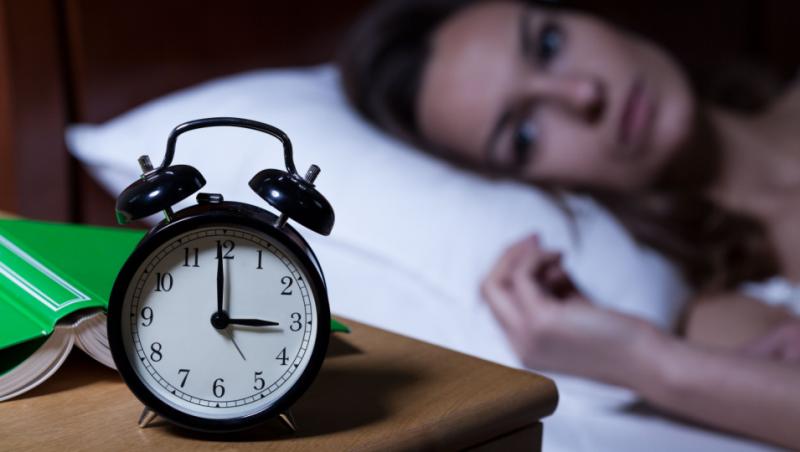 Imagine cu o femeie care are insomnii din cauza schimbării de oră.