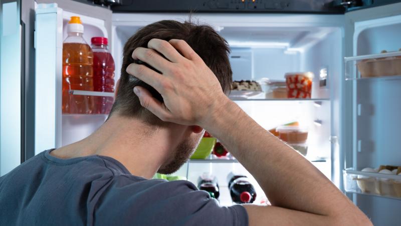 Un bărbat care nu știe ce să mai facă să combată mirosul neplăcut din frigider.