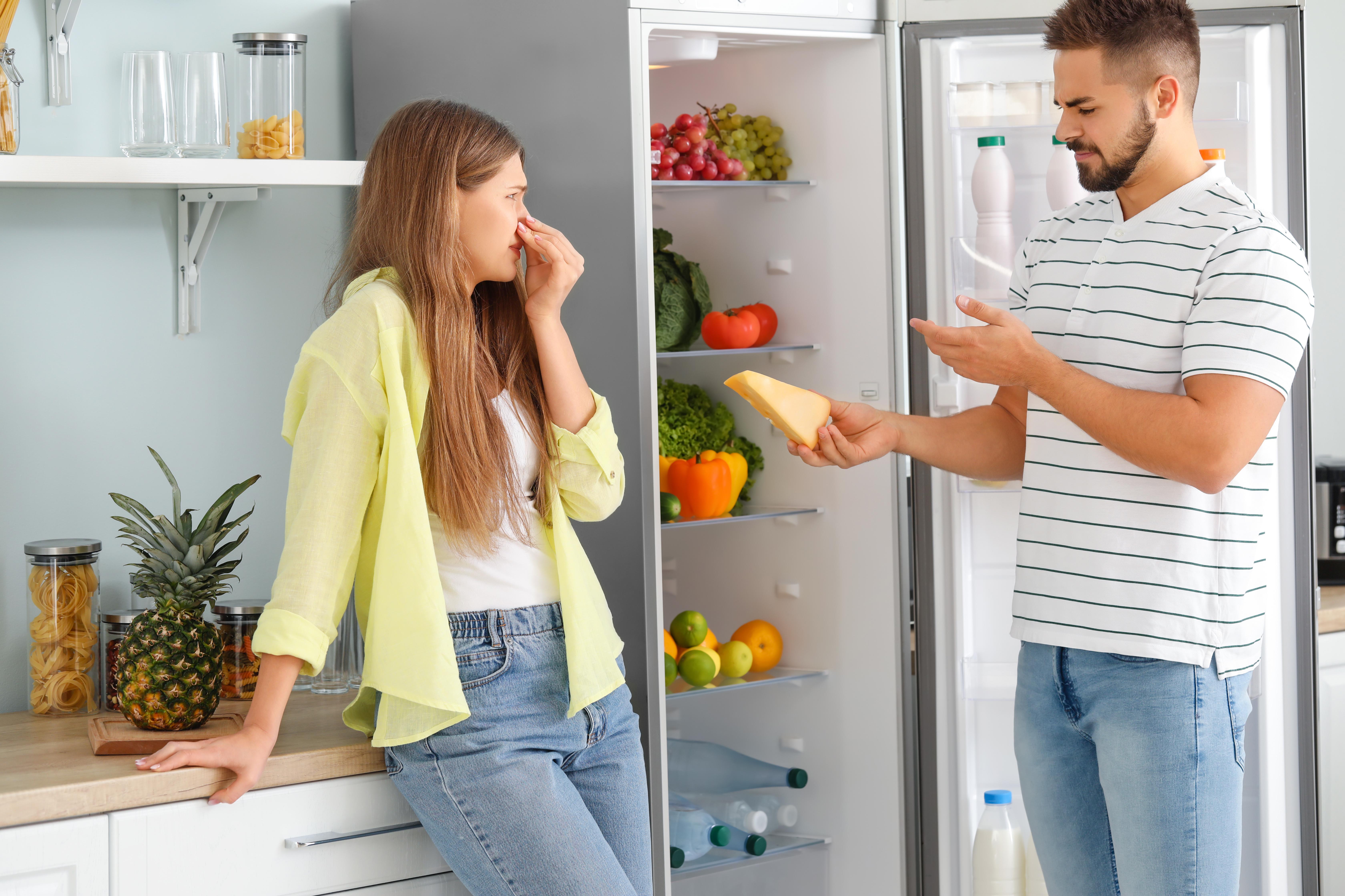 Imagine cu un cuplu care se plânge de mirosul neplăcut din frigider.