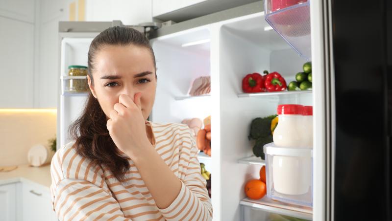 Femeie care nu poate să suporte mirosurile neplăcute din frigider.