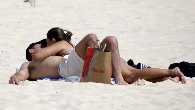Cuplul înflăcărat care s-a iubit pe plajă în văzul tuturor. Nu au mai ținut cont de privitori și s-au atins cu pasiune | FOTO