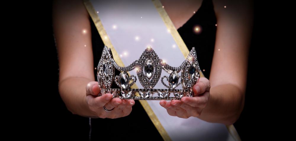 femeie care ține în mână o coroană pentru concursul de Miss